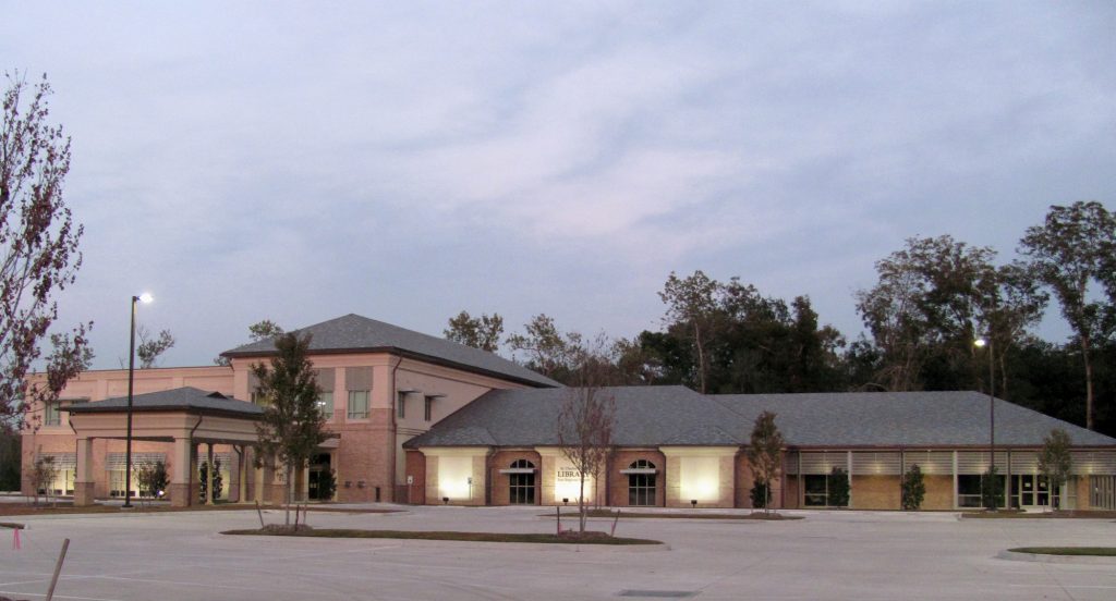 Twilight at a serene suburban community center with a spacious parking lot.