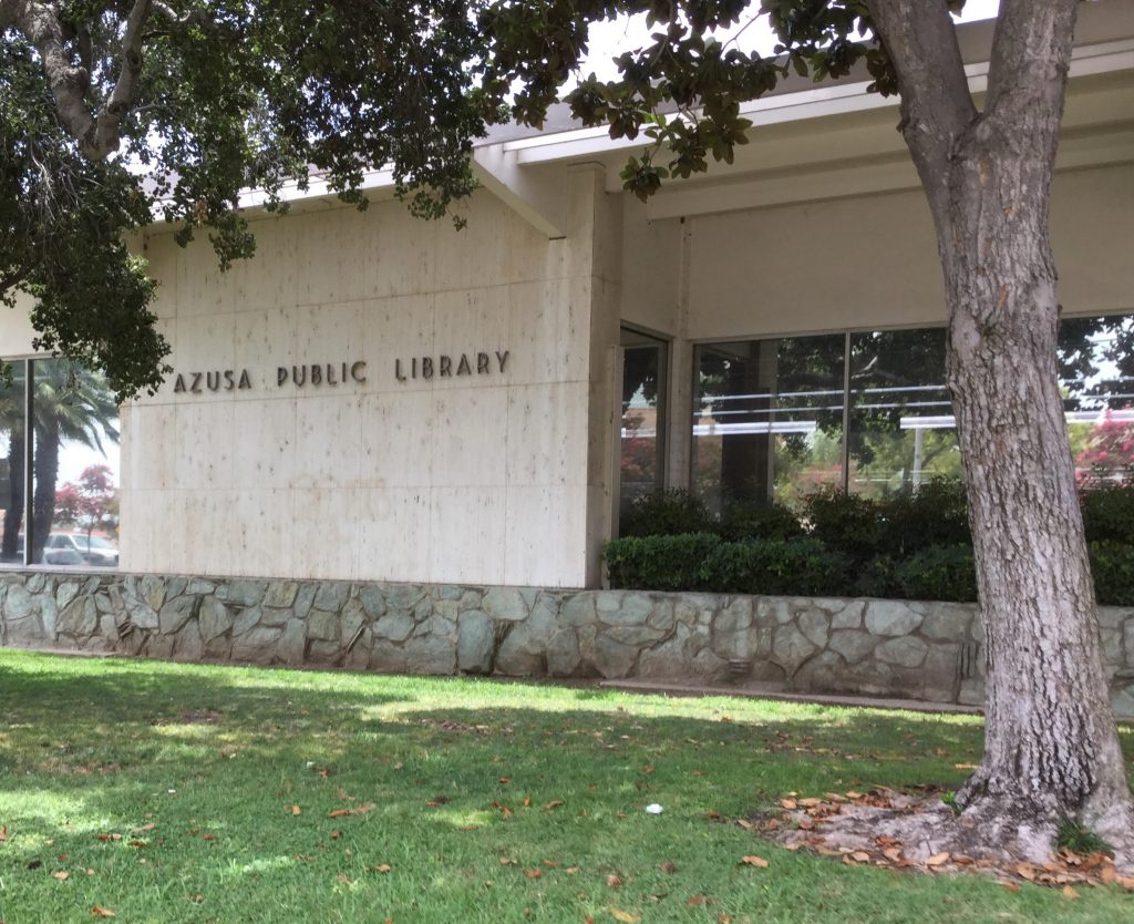 A quiet day outside the azusa public library, nestled among trees and greenery.