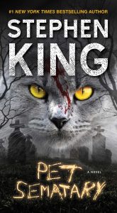 A haunting and intense book cover for stephen king's novel "pet sematary" featuring a close-up of a cat's face with ominous eyes superimposed over a foggy graveyard scene, suggesting a chilling and suspenseful tale.