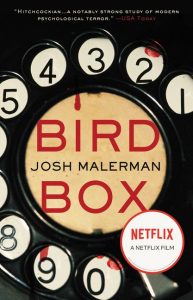 A book cover for "bird box" by josh malerman with a prominent endorsement stating it's a "notably strong study of modern psychological terror," as quoted by usa today. the cover features a vintage rotary phone dial with the numbers and letters visible through the dial holes, and the title "bird box" appears across the center. the netflix logo is also present, indicating a film adaptation available on the streaming platform.
