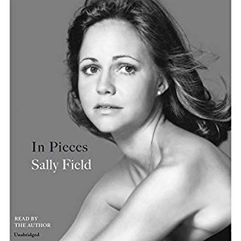 A black-and-white portrait of a contemplative woman on the cover of the audiobook "in pieces" by sally field, indicating that the story is a personal and possibly introspective narrative.