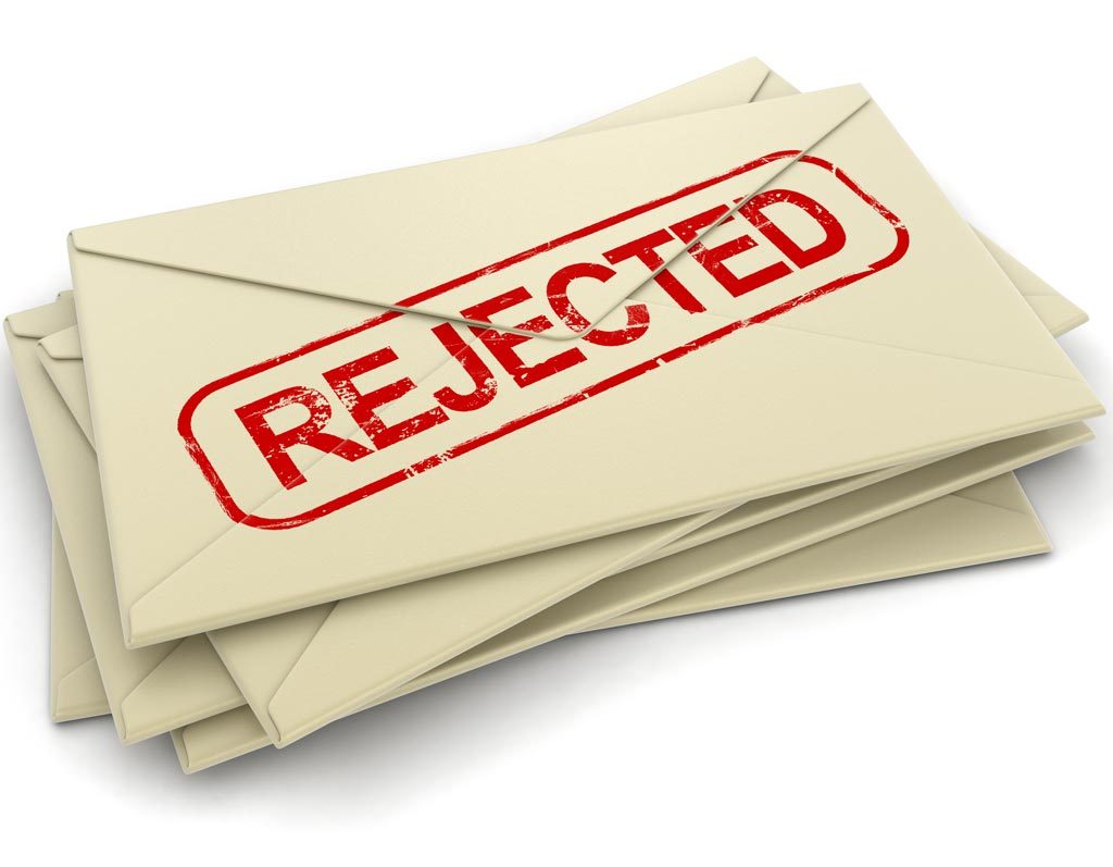 A stack of beige envelopes marked with a bold red "rejected" stamp.