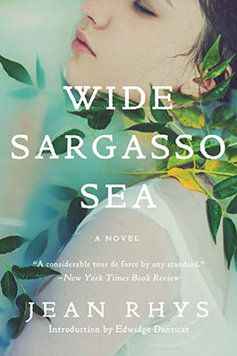 A contemplative young woman emerges among translucent leaves, evoking a sense of mystery and depth on the cover of jean rhys's novel "wide sargasso sea," praised by the new york times book review and featuring an introduction by edwidge danticat.