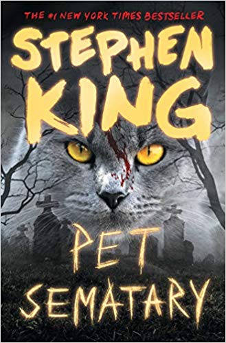 A haunting book cover for stephen king's "pet sematary," featuring the intense gaze of a cat with luminescent yellow eyes, promising a chilling tale within.