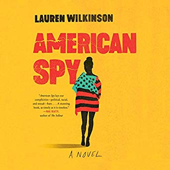 A silhouette of a person draped in an american flag against a vibrant yellow background, hinting at espionage themes for the novel "american spy" by lauren wilkinson.