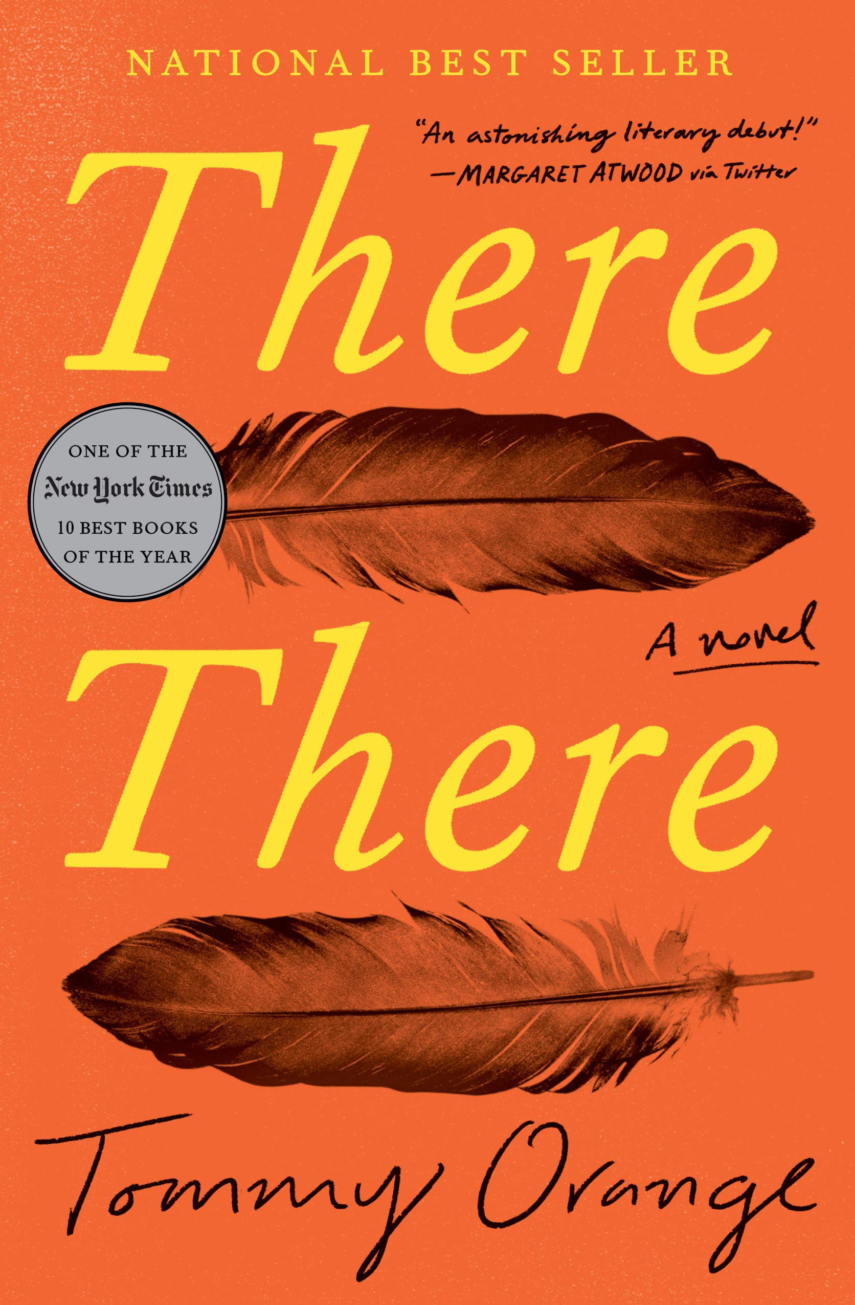 A vibrant red-orange book cover for the novel "there there" by tommy orange, featuring bold typography and stylized feather imagery, with accolades from esteemed author margaret atwood and a recognition as one of the 10 best books.