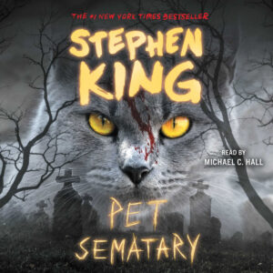 Cover of Stephen King's "Pet Sematary" with a gray cat, yellow eyes, and graveyard background.