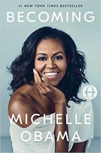 A portrait of a smiling woman featured on the cover of her memoir titled "becoming," signaling a story of personal growth and experiences.