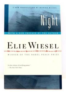 A photograph of the book "night" by elie wiesel, featuring a cover with a dark blue gradient and the author's name highlighted along with the mention of him being a nobel peace prize winner.