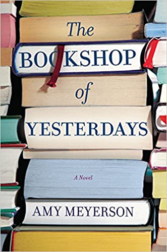 A stack of various books, with the novel "the bookshop of yesterdays" by amy meyerson prominently displayed at the front.