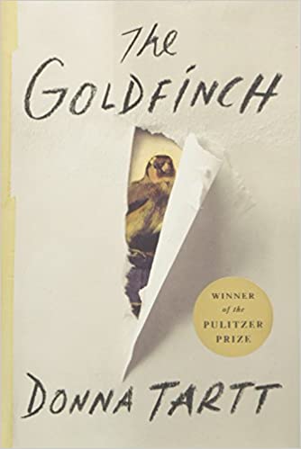 A book cover of "the goldfinch" by donna tartt, featuring a partially torn paper revealing a painting of a bird, with a label indicating the book is a pulitzer prize winner.