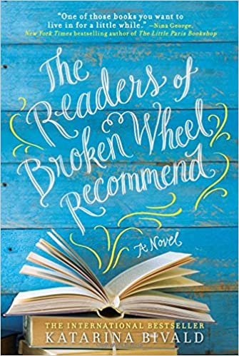 A book with its pages fanning out, set against a cover that reads "the readers of broken wheel recommend" by katarina bivald, with endorsements and the label 'international bestseller'.