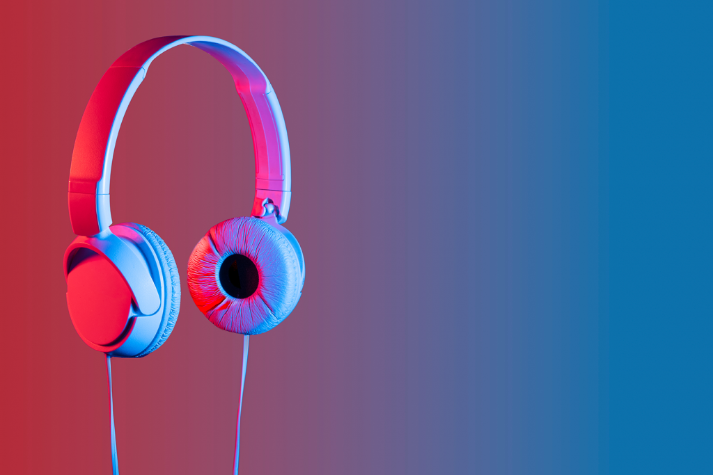A pair of headphones with a digitally manipulated image where one earcup has been creatively replaced by a human eye, against a dual-tone red and blue background.