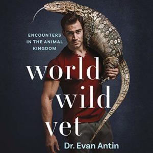 A confident veterinarian, dr. evan antin, poses with a large reptile draped over his shoulders against a dark background, highlighting his book "world wild vet" about encounters in the animal kingdom.