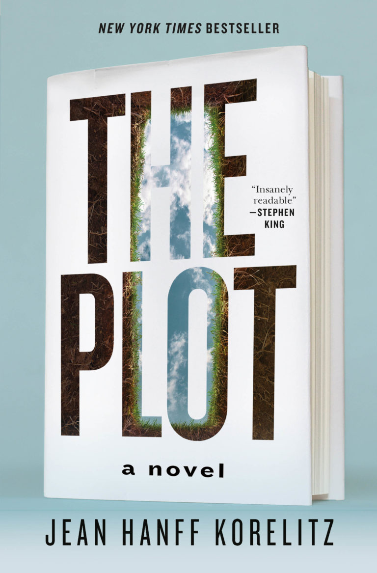 A book entitled "the plot" by jean hanff korelitz stands upright against a pale blue background, with the designation of "new york times bestseller" at the top and a quote describing it as "insanely readable - stephen king" on the cover design, which features a forest path seen through cut-out letters.