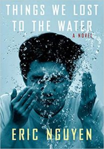 Book cover of 'things we lost to the water' by eric nguyen, depicting a young man submerged in water with air bubbles surrounding his face, conveying themes of submersion, loss, and reflection.