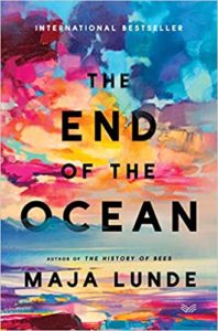 A book cover with vibrant watercolor splashes in pinks, blues, and yellows, titled "the end of the ocean" by maja lunde, labeled as an international bestseller.