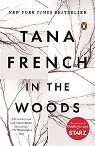 Cover of tana french's novel "in the woods," featuring stark tree branches against a white background, with the title and author's name prominently displayed.