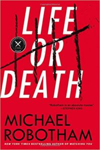 A striking book cover with bold red background featuring the title "life or death" in large white letters, with a black smudged cross-out effect across them, attributed to author michael robotham, praised as "an absolute master" by stephen king.