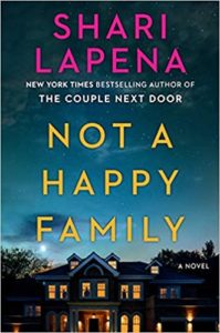 The cover of a novel titled "not a happy family" by shari lapena, depicting a large house at dusk with lights on in the windows, suggesting a mysterious or suspenseful family drama.