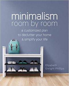 A neatly organized entryway featuring a white shoe rack with various pairs of shoes and a blue bag on top, set against a blue wall with the text "minimalism room by room - a customized plan to declutter your home & simplify your life by elizabeth enright phillips".