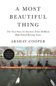 A team of rowers in sync on a tranquil river, with trees lining the shore and the reflection of the sky on the water, promoting the inspiring true story of determination and unity, "a most beautiful thing" by arshay cooper.