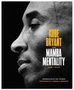 A close-up profile shot of a basketball player, focusing on his contemplative expression, overlaid with text for a book titled "kobe bryant: the mamba mentality - how i play" with an introduction by phil jackson and photographs by andrew d. bernstein.