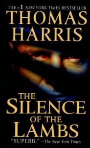 A book cover featuring a close-up of an intense gaze with a moth superimposed over the mouth, for thomas harris's novel "the silence of the lambs," acclaimed as superb by the new york times.