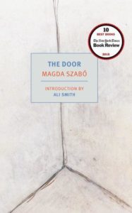 A minimalist book cover design featuring converging lines suggesting a door, with the title 'the door' by magda szabó prominently displayed, featuring a commendation from the new york times book review for being one of the 10 best books of 2015.