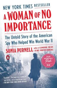 A striking book cover for 'a woman of no importance' by sonia purnell, featuring a silhouette of a woman against a bold red background, highlighting the remarkable story of an american spy and heralded by glowing reviews.