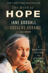 A book cover featuring jane goodall, with the title "the book of hope" and the subtitle "a survival guide for trying times." the book is noted as a new york times bestseller and is co-authored by douglas abrams with gail hudson. jane goodall's thoughtful gaze suggests a reflective mood, fitting for a book about hope and survival.