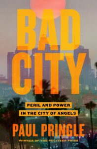 A dramatic book cover for "bad city" featuring an ominous city skyline at dusk with large, bold lettering and the promise of a story filled with peril and power in the city of angels, written by pulitzer prize winner paul pringle.