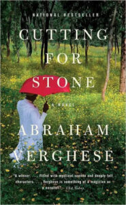 An individual under a vibrant red umbrella walking through a serene, tree-filled landscape graces the cover of 'cutting for stone,' a novel by abraham verghese.