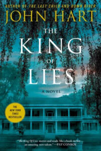 The king of lies" by john hart, featuring a haunting image of a dilapidated building overgrown with ivy, hinting at mystery and secrets hidden within its walls.