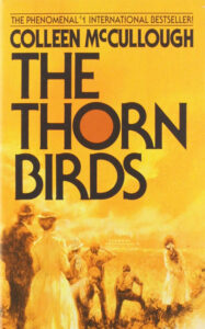Vintage book cover of "the thorn birds" by colleen mccullough with illustration of people in a pastoral setting.