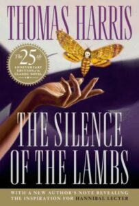 A book cover for thomas harris' "the silence of the lambs," featuring a hand reaching out towards a moth with a skull-like pattern on its back, commemorating the 25th anniversary of the classic novel.