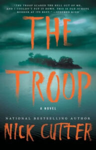 A chilling book cover for "the troop" by nick cutter, with an ominous atmosphere evoked by the dark, forested backdrop and stark, bold lettering that promises a gripping horror story.