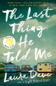 A book cover for the novel "the last thing he told me" by laura dave, featuring houseboats on a calm body of water, with a cloudy sky above, and the title in large, stylized white print over the image.