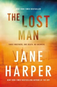 The image is of a book cover titled "the lost man" by jane harper, noted as a new york times bestseller. the cover features a blend of warm colors, suggesting a setting or theme involving the outdoors, with a possible atmospheric or dramatic undertone, conveyed through the tagline, "three brothers, one death, no answers...