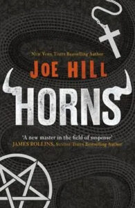 A dark and textured book cover with the title "horns" in large, distressed silver letters, by author "joe hill." it is praised as a work by "a new master in the field of suspense" by james rollins, as indicated on the cover, which also features a stylized pitchfork and pentagram symbol beneath the text.