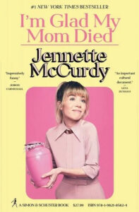 A woman in a pink outfit holding a pink urn smiles in a promotional poster for jennette mccurdy's book titled "i'm glad my mom died," with critical praise and the details of its bestseller status displayed around her.