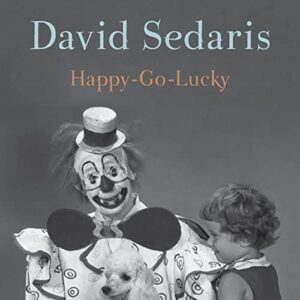 A vintage-inspired image showcasing a clown in traditional makeup and costume smiling beside a small child holding a dog, set against a muted background, evoking a nostalgic and possibly unsettling atmosphere, with the title 'david sedaris happy-go-lucky' overlaid in a contrasting font.