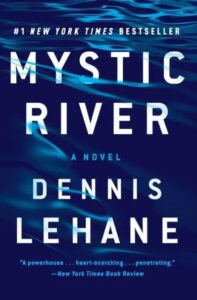 Mystic river" novel cover by dennis lehane, boasting its status as a #1 new york times bestseller and backed by a review highlighting it as a "powerhouse...penetrating.