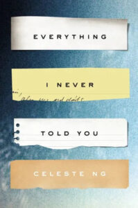 The image shows a book cover with an artistic arrangement of text labels against a textured background. the book's title "everything i never told you" is fragmented across three separate strips of paper, with the author's name, celeste ng, on a fourth strip at the bottom.