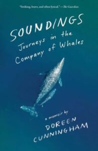 A tranquil underwater view with a whale gliding through the deep blue sea, featured on the cover of "soundings: journeys in the company of whales" by doreen cunningham.