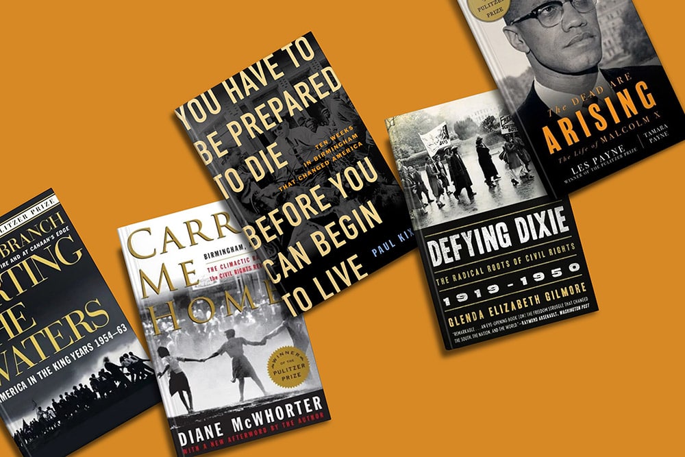 A collection of civil rights-themed books laid out on an orange background, showcasing the historical struggles and inspiring messages of the civil rights movement.
