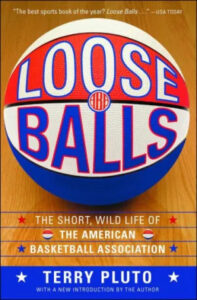 A vibrant book cover featuring a stylized basketball with the title "loose balls" emblazoned across it and the subtitle "the short, wild life of the american basketball association" by terry pluto, lauded as "the best sports book of the year" by usa today.