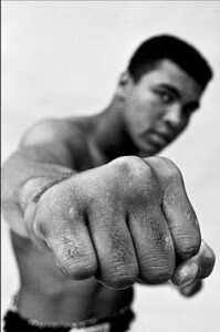 A focused boxer, fist clenched and ready, exudes determination and strength.