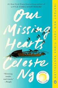 A book cover for "our missing hearts" by celeste ng, featuring a turquoise background with dark birds flying upwards, a single brown leaf tethered by a string, and various critical acclaim quotes and bestseller badges.