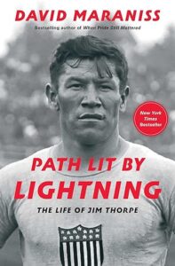 A book cover highlighting the biography of legendary athlete jim thorpe, titled "path lit by stars: the life of jim thorpe" by david maraniss, noted as a new york times bestseller.